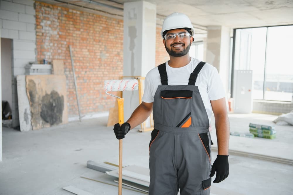 Painter holding a roller in a room under renovation